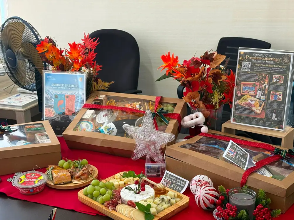 Gourmet gift boxes displayed with festive decorations, a cheese board and smoked salmon